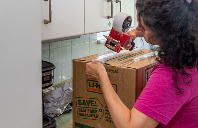 Employee taping a box closed